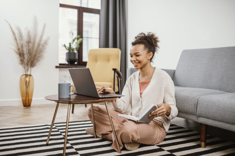 woman reading a book by the computer